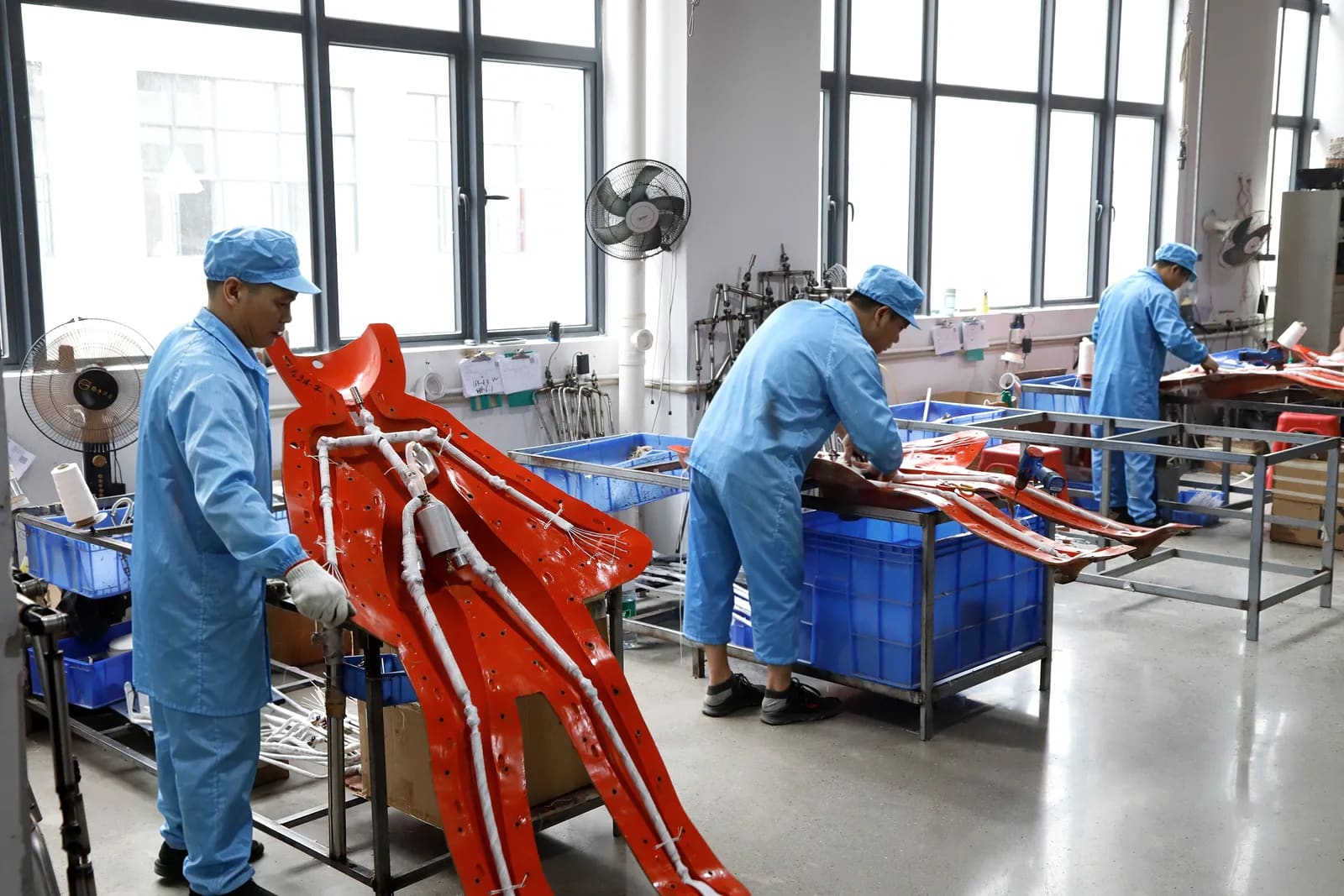 Technicians assembling reinforced doll bodies in a bright workshop