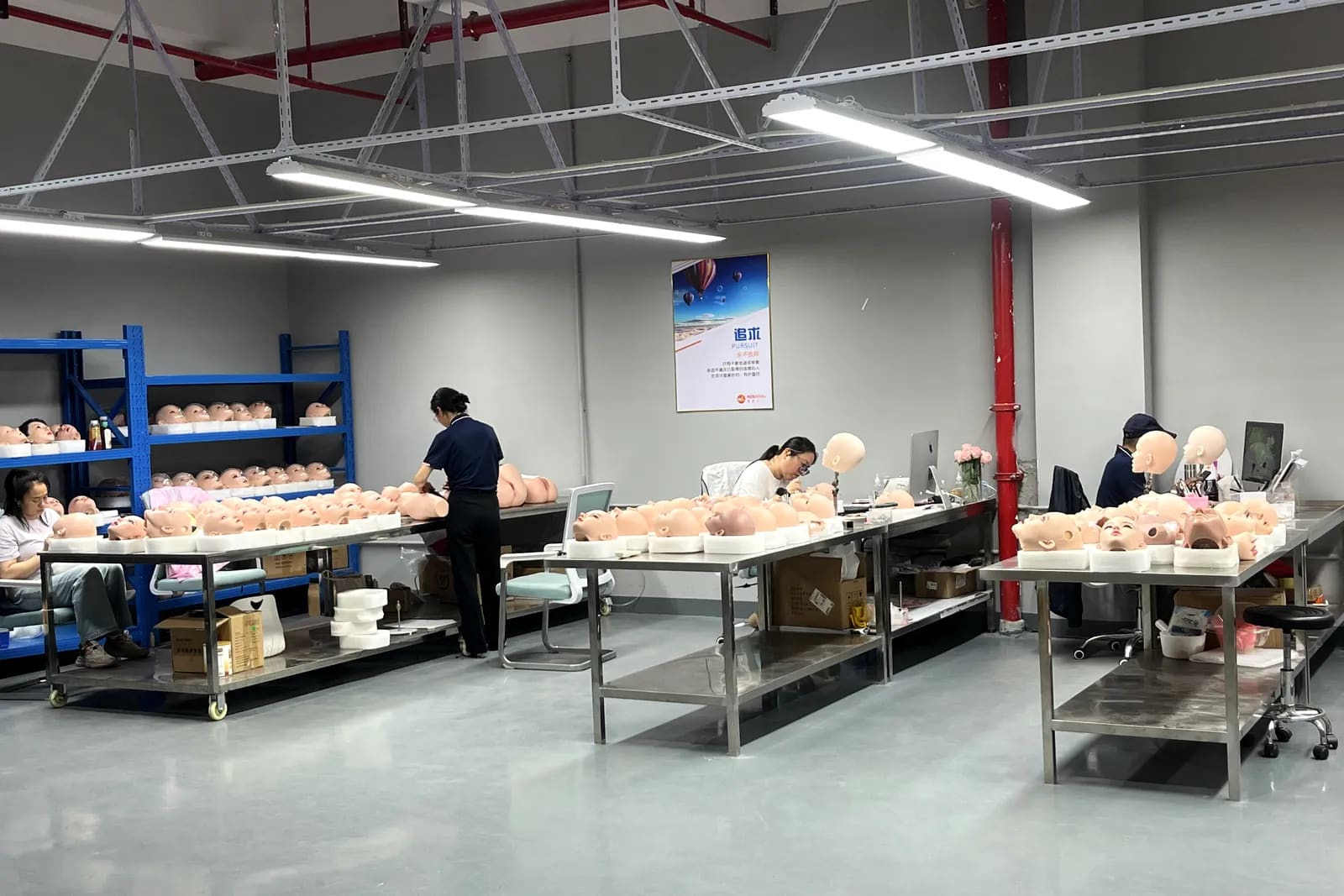 Rows of hand-painted doll faces moving through a finishing station