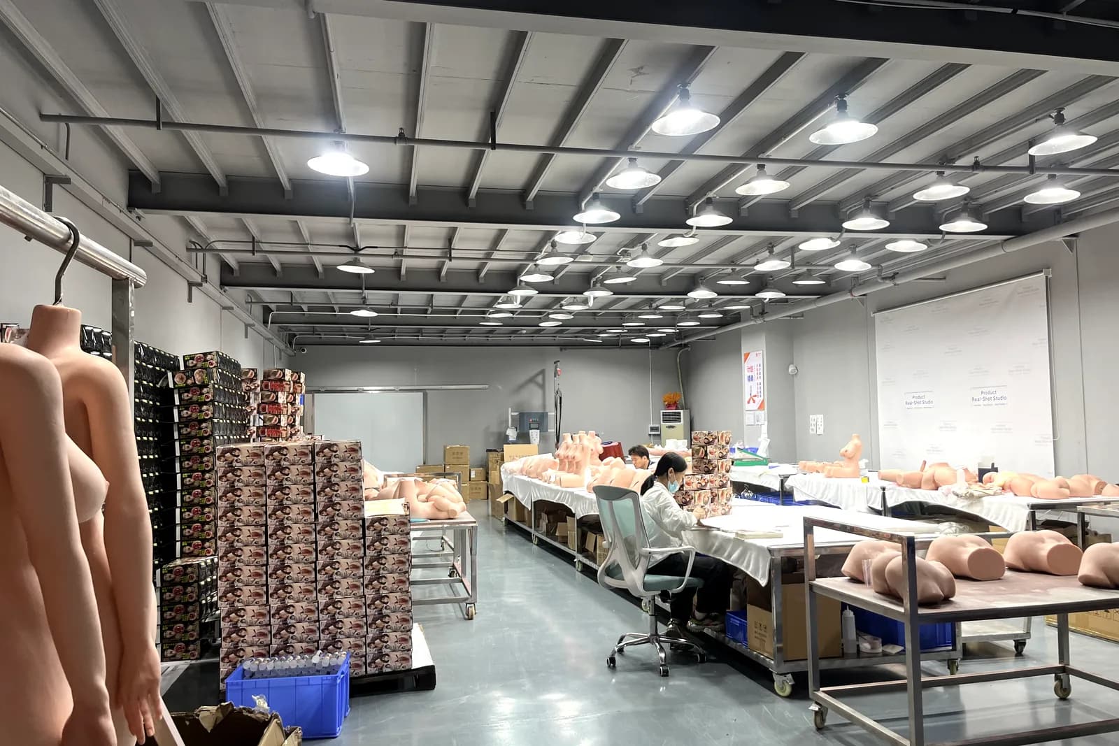 Finished dolls being checked under bright studio lighting before dispatch